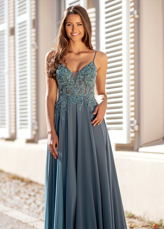 Das Model strahlt vor Glück und präsentiert sich stolz der Kamera in einem Abendkleid von Christian Koehlert.